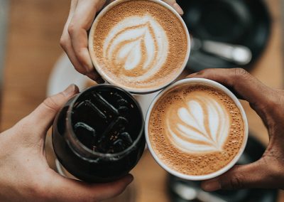 Drei Kaffeegetränke in der Mitte des Bildes